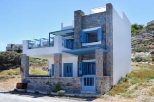 a house with blue doors on a hill at New Seaview Villa Moments with Rooftop Hot Tub, 50m from the Beach in Mochlos