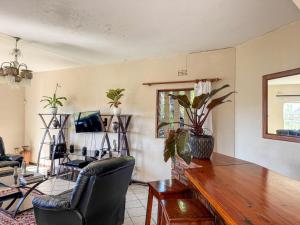 a living room with a wooden table and chairs at Palm Grove Lodge in Margate