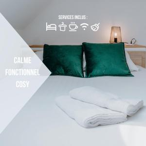 Bett mit weißer Bettwäsche und grünen Kissen in der Unterkunft La Maison MMM - Proche Centre & Commerces in Châteauroux