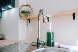 eine Küchenspüle mit einem Wasserhahn auf der Theke in der Unterkunft La Maison MMM - Proche Centre & Commerces in Châteauroux