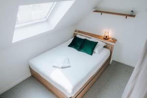 ein Schlafzimmer mit einem weißen Bett und einem grünen Kissen in der Unterkunft La Maison MMM - Proche Centre & Commerces in Châteauroux