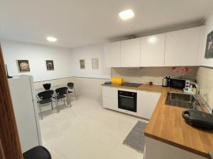 a kitchen with white cabinets and black appliances at Apartamento "Vila Serena Marisol" in Corroios