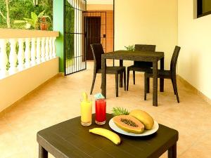 a table with a plate of food on a table with fruit at Villa Rosa in San Felipe de Puerto Plata