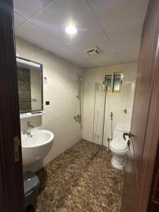 une salle de bain avec un lavabo et des toilettes dans l'établissement فندق برايت, à La Mecque