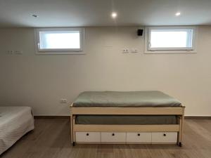 a bedroom with two beds and two windows at Loft Puerto Real in Puerto Real