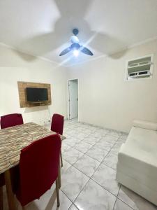 a living room with a table and a ceiling fan at A 1 Minuto da praia in Santos +8 photos