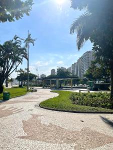 a walkway in a park with palm trees and buildings at A 1 Minuto da praia in Santos