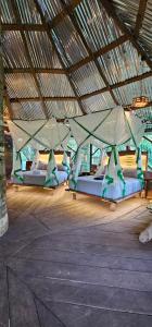 a group of beds in a building with a roof at Casa del árbol - Kiosko el Tacana in Leticia