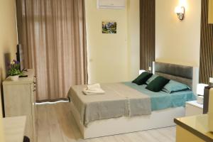 a bedroom with a bed with blue and green pillows at New Batumi City Center in Kakhaberi +26 photos