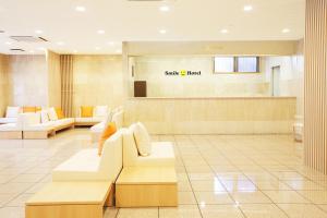 a lobby with white couches and a waiting room at Smile Hotel Sugamo in Tokyo