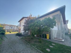 a house with a tree in front of it at Casa Ortensia Saronno in Saronno
