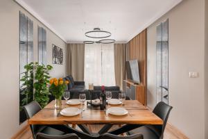a dining room with a table and chairs at Jesionowe Apartamenty Ashwood Apartments Widok na Odrę 1,4 km od Rynku Parking Podziemny w Cenie Klimatyzacja Sauna w 1 Apt River Oder view 1,4 km Market Square Underground parking Balcony Air conditioning in Wrocław