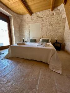 een slaapkamer met een groot bed in een stenen muur bij Nidus Petrae in Alberobello