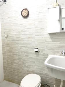 a bathroom with a toilet and a sink at Pé na areia Santos in Santos