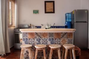 a kitchen with a counter with stools and a refrigerator at Kay Apartments Isla Mujeres in Isla Mujeres +35 photos
