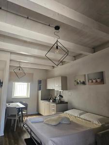 a bedroom with a large bed and a kitchen at appartamenti Il Borgo orchidea in Busca