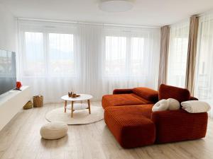 een woonkamer met een rode bank en een tafel bij A2 Severna Apartment, near City Center and High Tatras in Poprad