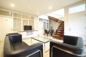 a living room with a couch and a glass table at Dago 207 in Bandung