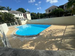 a swimming pool in the backyard of a house at L'ile aux couleurs in Les Abymes