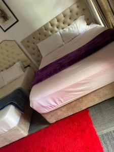 a bedroom with a large bed with a red rug at two lovers in Vosburg