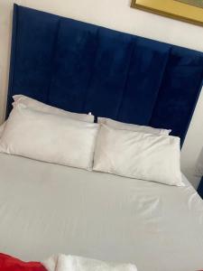 a bed with three white pillows on top of it at two lovers in Vosburg