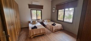 a room with two beds and two windows at Maison des Couleurs in Aley