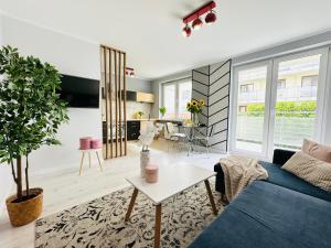 a living room with a blue couch and a table at Apartament Kryształowy - Kołobrzeg in Kołobrzeg