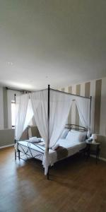 Un dormitorio con una cama grande con dosel. en Villa Celeste, en Murazzo