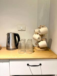 een aanrecht met een koffiezetapparaat en glazen erop bij Non Inn The Barber King and Twin Rooms with Vintage Charm and Unique Design near Riverside and ICONSIAM in Bang Rak