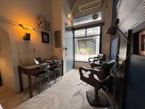 een kamer met een kapsalon met een bureau en stoelen bij Non Inn The Barber King and Twin Rooms with Vintage Charm and Unique Design near Riverside and ICONSIAM in Bang Rak +7 foto's