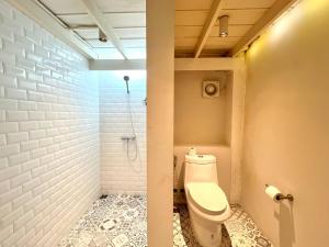 een badkamer met een toilet en een douche bij Non Inn The Barber King and Twin Rooms with Vintage Charm and Unique Design near Riverside and ICONSIAM in Bang Rak