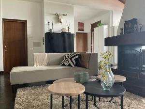 a living room with a couch and tables and a fireplace at Villa Belvedere Panorama Lakeview - Lago di Como in Menaggio