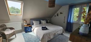 a bedroom with a bed and a chair and a window at Cottage on the Hill in Kielno +58 photos
