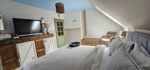 ein Wohnzimmer mit einem Bett und einem Flachbildfernseher in der Unterkunft Cottage on the Hill in Kielno