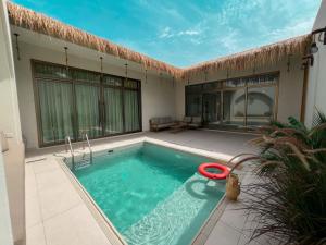 a swimming pool in front of a house at Celia Chalet شاليهات سيليا in Al Mubarraz