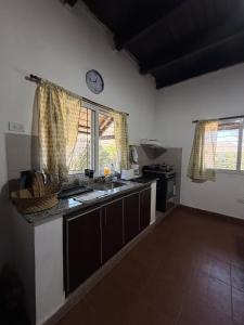 a kitchen with a sink and a clock on the wall at El descanso in El Rodeo