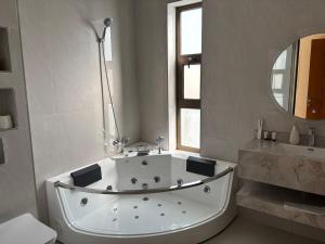 a white bath tub in a bathroom with a mirror at Celia Chalet شاليهات سيليا in Al Mubarraz +21 photos