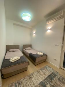two beds in a small room with a light at BASC Modern 2 in Sarajevo
