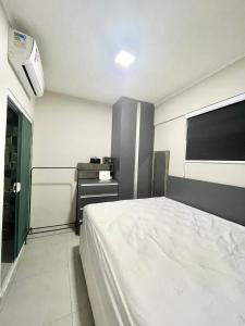 a bedroom with a white bed and a desk at Santos Prime Stay in Santos