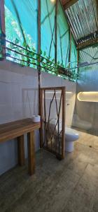 a bathroom with a toilet and a wooden bench at Casa del árbol - Mirador Tacana in Leticia