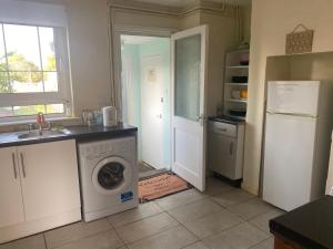 ニューマーケットにあるCharlies House Newmarket - 3 bedroomのキッチン(洗濯機、冷蔵庫付)