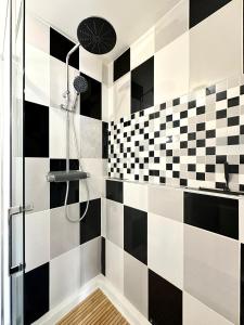 DéolsにあるLogement entier climatisé Grangeroux 5 mn du Centre National de Tirsの黒と白のチェックタイルのバスルーム