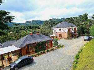 a house with a car parked in front of it at Pousada Chales da Mantiqueira - Campos do Jordão in Campos do Jordão