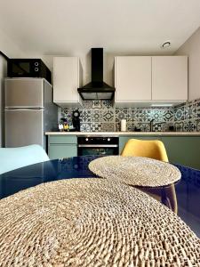 DéolsにあるLogement entier climatisé Grangeroux 5 mn du Centre National de Tirsの円形のテーブルと黄色い椅子のあるキッチン