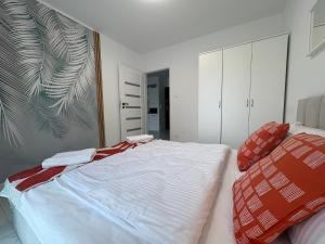 a bedroom with a large white bed and a mirror at Aura Apartamenty in Brzeg