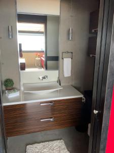 a bathroom with a sink and a mirror at Modern apartment with magnificent views in Vaudreuil-Dorion