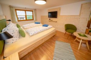a bedroom with two beds and a table and a television at Weißenbach´s Ferienhof in Wertach