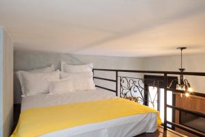 Un dormitorio con una cama amarilla y blanca en un balcón en LOFT LAPA Baldô, en Río de Janeiro