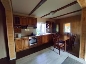 a kitchen with wooden cabinets and a table and chairs at Domek Letniskowy Agroturystyka Motwica  +21 photos
