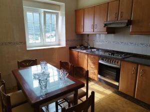 a kitchen with a table and a dining room at Casa A Peneda in Dumbría